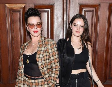 Evelina Corcos in black poses with mother Debi Mazar.